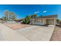 Single-story home with a covered carport and mature landscaping, offering curb appeal at 7345 W Beryl Ave, Peoria, AZ 85345