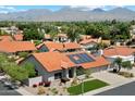 Aerial view of a single-story home with a three-car garage, red tile roof and solar panels in a lush neighborhood at 10510 E Terra Dr, Scottsdale, AZ 85258
