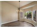 Bright dining room with wood-look floors, a modern chandelier, and a large window offering natural light at 10510 E Terra Dr, Scottsdale, AZ 85258