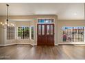 Inviting foyer with rich wood floors, decorative front doors, large picture windows, and elegant lighting at 10510 E Terra Dr, Scottsdale, AZ 85258
