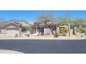 Charming single-story home with desert landscaping, an attached two-car garage, and partial mountain views at 10694 E Firethorn Dr, Scottsdale, AZ 85255