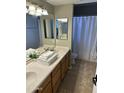 Functional bathroom with a double sink vanity and a shower with neutral tile and curtain at 1081 W 1St St # 18, Tempe, AZ 85281