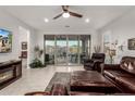 Bright living room featuring sliding glass doors, tile flooring, and comfortable leather seating at 13384 W Red Range Way, Peoria, AZ 85383