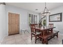 Dining room with wood table, bench seating, chandelier, and window with shutter; tiled floors at 1508 S Danyell Pl, Chandler, AZ 85286