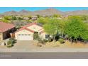 Exterior view of a single-story home showcasing a well-maintained front yard with desert landscaping and mountain views at 17514 W Desert Sage Dr, Goodyear, AZ 85338