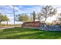 Golf Village community entrance sign with lush green lawn and desert foliage at 17514 W Desert Sage Dr, Goodyear, AZ 85338
