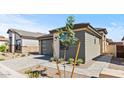 A modern home featuring a gray garage door and neutral stucco and siding, complemented by a brick driveway at 20332 W Sells Dr, Buckeye, AZ 85396