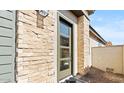 A modern front door with stone detail surround and a low maintenance front yard at 20332 W Sells Dr, Buckeye, AZ 85396