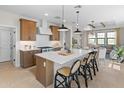 Spacious kitchen featuring stainless steel appliances, a kitchen island, and seamlessly connecting to the living room at 20332 W Sells Dr, Buckeye, AZ 85396