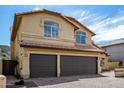 Spacious three-car garage with brick paved driveway and tan stucco exterior at 20713 N 56Th Ave, Glendale, AZ 85308