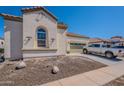 A bright and sunny exterior elevation featuring a beige stucco finish, terracotta roof, and two-car garage at 514 E Pearce Rd, Phoenix, AZ 85042