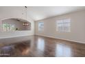 Bright living room featuring a modern light fixture, wood floors, and multiple windows with bright natural light at 514 E Pearce Rd, Phoenix, AZ 85042