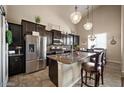 Modern kitchen featuring stainless steel appliances, dark cabinetry, and granite countertops at 514 E Pearce Rd, Phoenix, AZ 85042
