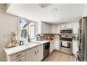 Bright kitchen features stainless steel appliances, white cabinetry, and a marble-look countertop at 5350 N 3Rd Ave, Phoenix, AZ 85013