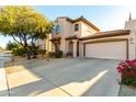 Attractive home featuring stucco siding, a terracotta roof, a two-car garage, and desert landscaping at 5423 W Range Mule Dr, Phoenix, AZ 85083