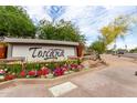 Community sign with colorful flowerbeds and manicured landscaping creating curb appeal at 5450 E Deer Valley Dr # 3003, Phoenix, AZ 85054