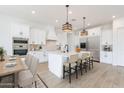 Bright, open kitchen features white cabinets, stainless steel appliances, and a large island at 6514 W Apex Ave, Queen Creek, AZ 85144