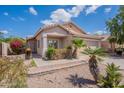 Inviting exterior view of home showing desert landscaping, palm trees and charming facade at 8010 W Adam Ave, Peoria, AZ 85382