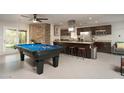 Open-concept kitchen and game room with an island, modern appliances, and a pool table at 8220 E Crestwood Way, Scottsdale, AZ 85250