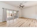 Spacious bedroom with wood floors, ceiling fan, sliding glass doors to the patio, and lots of natural light at 13821 N Thunderbird Blvd, Sun City, AZ 85351
