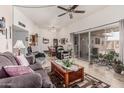 Spacious living room featuring a ceiling fan, light wood floors, and sliding glass door to the outside patio at 13821 N Thunderbird Blvd, Sun City, AZ 85351