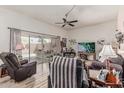 Comfortable living room with a ceiling fan, wood floors, and sliding glass door leading to the patio at 13821 N Thunderbird Blvd, Sun City, AZ 85351