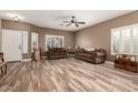 Inviting living room with wood-look floors, a ceiling fan, and bright windows at 14282 W Indianola Ave, Goodyear, AZ 85395