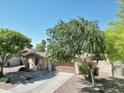 Lovely home with a tile roof, xeriscaped yard, and a mature tree providing shade and curb appeal at 1516 E Azalea Dr, Gilbert, AZ 85298