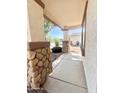 Charming front porch with stone-accented columns and a view of the well-maintained front yard at 1516 E Azalea Dr, Gilbert, AZ 85298