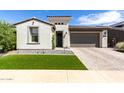 Charming single-story home with manicured landscaping, stone accents, and a brick-paved driveway leading to a two-car garage at 17168 W Mountainair St, Surprise, AZ 85388