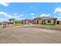 Beautiful home exterior with landscaped rock features and lush green synthetic grass at 18225 W San Juan Ct, Litchfield Park, AZ 85340