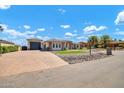 Wide shot of home with three garages, beautiful brick driveway, and green synthetic grass at 18225 W San Juan Ct, Litchfield Park, AZ 85340