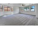 Bright living room featuring neutral carpet, recessed lights and large windows providing ample natural light at 21334 E Lords Ct, Queen Creek, AZ 85142