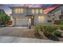 Charming two-story home with a two-car garage and a welcoming front entrance at sunset at 21716 S 225Th Way, Queen Creek, AZ 85142