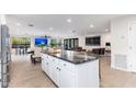 Kitchen island with bar seating, stainless steel appliances, and open view to the living room with large TV at 2712 E Mountain View Rd, Phoenix, AZ 85028