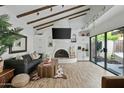 Inviting living room with vaulted ceilings, wood beams, a fireplace, and sliding glass doors to a peaceful patio at 2839 N 61St St, Scottsdale, AZ 85257