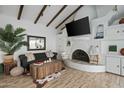 Cozy living room featuring a fireplace, vaulted ceilings with beams, and stylish decor, creating a warm ambiance at 2839 N 61St St, Scottsdale, AZ 85257
