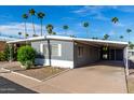 Charming single-story home with covered parking, desert landscaping, and palm trees at 303 S Recker Rd # 141, Mesa, AZ 85206