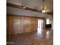Living room with tile floors, wood-beam accents, and wood paneling at 36655 N 25Th St, Cave Creek, AZ 85331