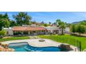 Expansive backyard with pool, fire pit, outdoor kitchen, and covered patio, perfect for entertaining at 5838 E Berneil Ln, Paradise Valley, AZ 85253