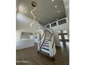 Stunning foyer with a curving staircase, wood floors, and modern chandelier creating a grand entrance at 6337 W Deer Valley Rd, Glendale, AZ 85308