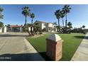 Charming home with manicured lawn, palm trees, and gated driveway at 6337 W Deer Valley Rd, Glendale, AZ 85308