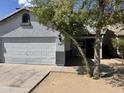 Exterior view of home featuring the two-car garage and covered entry way and neat landscaping at 720 W Lydia Ln, Phoenix, AZ 85041