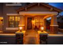 Inviting front porch with decorative columns, stylish front door, and comfortable seating at 9566 N 83Rd Dr, Peoria, AZ 85345
