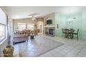 Spacious living room with tile flooring, a ceiling fan, and fireplace with stone hearth and decorative mantle at 10387 W Runion Dr, Peoria, AZ 85382