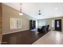 Inviting living room features dark wood flooring, neutral walls, and stylish shuttered windows at 10504 E Diamond Ave, Mesa, AZ 85208