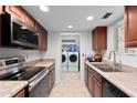 Efficient kitchen with stainless steel appliances and a view into the laundry area, providing convenience and functionality at 15801 N 29Th St # 16, Phoenix, AZ 85032