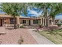 Charming single-story home with covered porch, desert landscaping, trees and brick walkway at 1822 W Rose Ln, Phoenix, AZ 85015