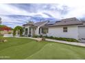 Well-maintained home exterior with green lawn, putting green, and lush landscaping at 18843 N 45Th Ave, Glendale, AZ 85308
