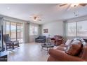Spacious living room with tile flooring, ceiling fans, and large windows offering abundant natural light at 21277 E Cherrywood Dr, Queen Creek, AZ 85142